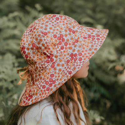 Side view of girl wearing Bedhead Hats Wanderer Melody sun hat with red and orange flowers