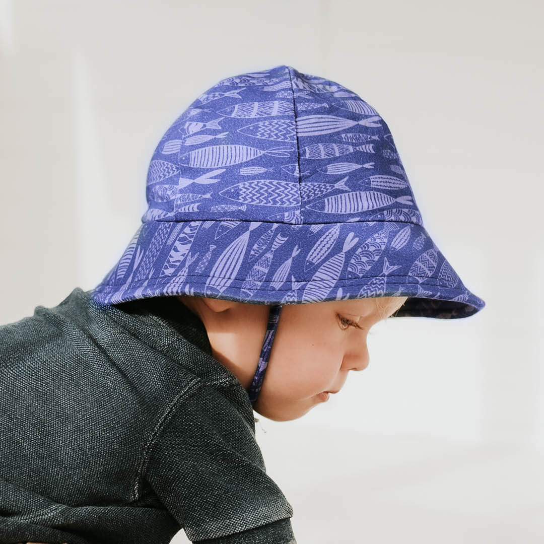Bedhead Hats toddler boys bucket hat with fish print on blue background on boy